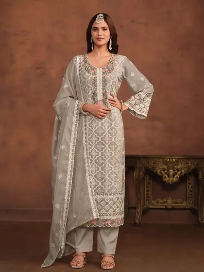 A graceful grey salwar kameez with delicate floral and geometric thread embroidery. The organza fabric and detailed hem on the pants and dupatta add a touch of luxury.
