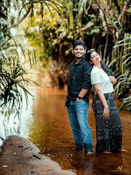 An intimate back-to-back pose in a stream, capturing a quiet and connected moment during their pre-wedding shoot.
