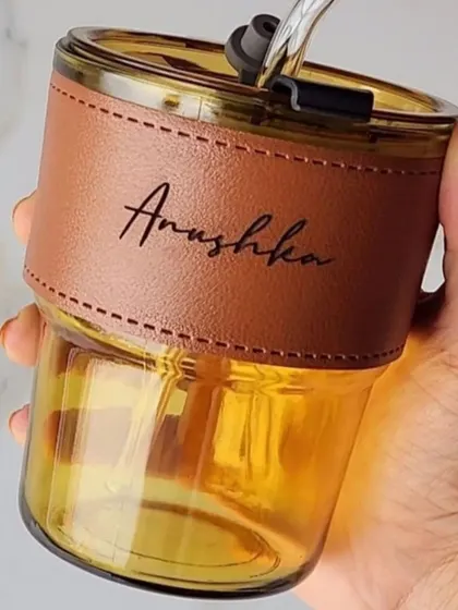 A closer look at the fine engraving on my personalized glass coffee sipper. The name is clearly visible on the tan leather sleeve, making it a classy and personal item.