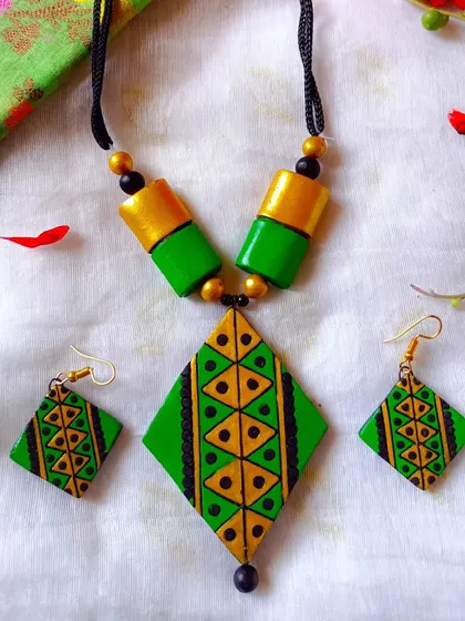 A vibrant green and gold version of the diamond-pendant set.