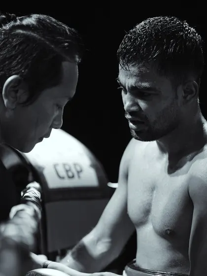 The crucial bond between coach and fighter. A black and white shot capturing a moment of intense strategy in the corner.