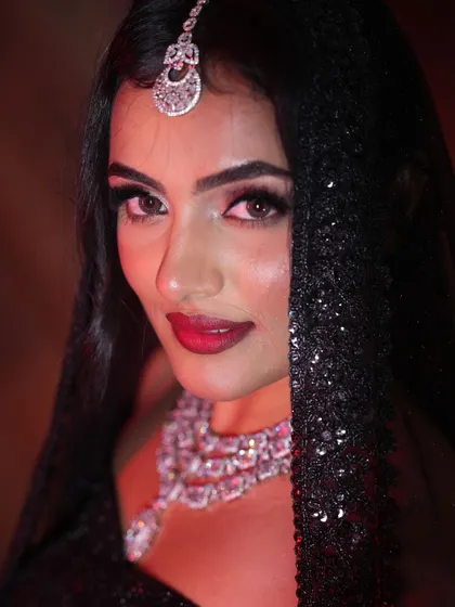A close-up portrait of the model with a sheer black dupatta, creating a mysterious and alluring look. This is perfect for a dramatic evening entrance.