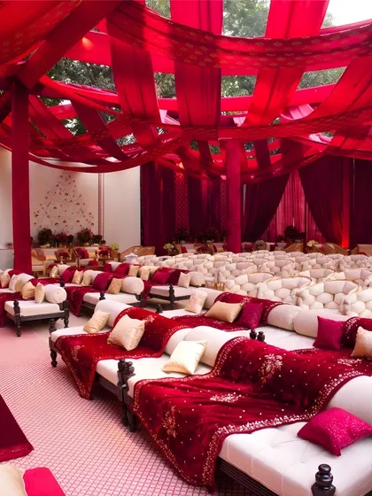 For this Sufi night, I created a traditional low-seating arrangement with plush red velvet cushions and bolsters. The overhead fabric draping in deep red hues made the space feel intimate and luxurious.