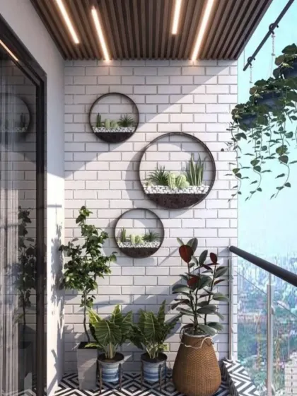 A bright and sunny balcony featuring a white brick wall adorned with circular wall planters. This design choice adds a playful and artistic touch, complemented by hanging vines and patterned floor tiles for a fresh, modern look.