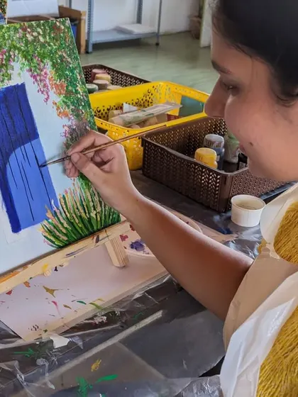 A participant carefully painting the details on her blue door canvas.