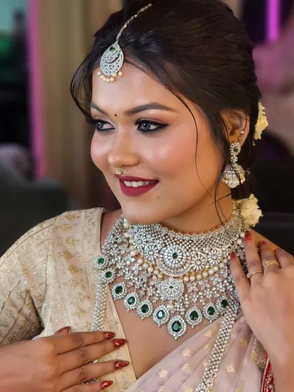 Another angle of this beautiful look, highlighting the intricate details of the diamond and emerald necklace and the soft, elegant updo.