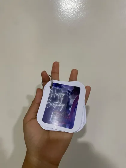 A hand holding the birthday-themed memory keychain. The compact size makes it easy to attach to keys or a bag, so your memories are always close by.