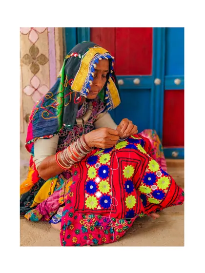 A Meghwal woman in Kutch is deeply focused on her intricate embroidery work. This craft is a visual language for her community, with every stitch telling a story.