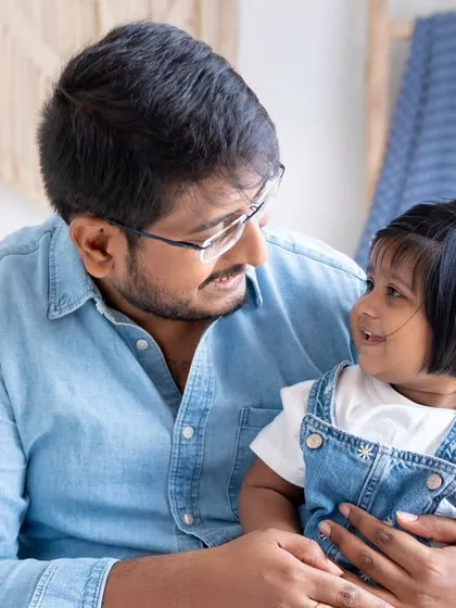 A father and daughter share a sweet, knowing look. These quiet, in-between moments often make for the most powerful and authentic portraits of family connection.