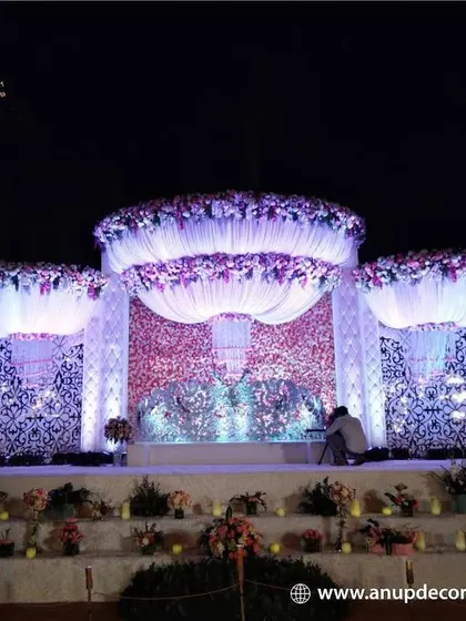 This reception stage showcases our expertise in creating large, intricate structures. The design features a detailed jali-work backdrop, dramatic draping, and massive floral arrangements for a truly royal feel.