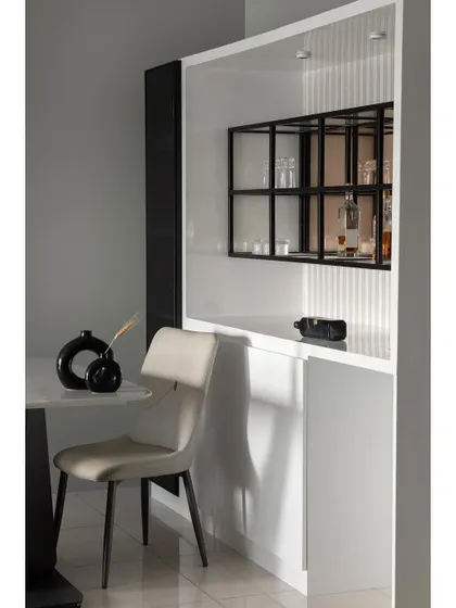 This detail shot highlights the custom bar and crockery unit. The design features a mix of open and closed storage, with a black metal grid shelf for displaying glassware, set against a white fluted backdrop.