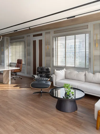 Natural light floods the executive cabin, highlighting the warm wood flooring and the comfortable seating area. This corner is perfect for informal discussions or a moment of quiet reflection during a busy day.