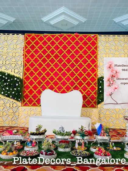 This seer varisai table is set against a modern geometric backdrop. The silver trays and elevated stands give the entire gift presentation a very grand and organized feel.