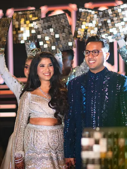 Natasha and Pranshu making their grand entrance at the sangeet. Natasha is sparkling in a mermaid-style Manish Malhotra lehenga, a perfect choice for a glamorous dance-filled night.