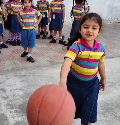 A student confidently handles the basketball, showcasing the skills and enjoyment that come from our sports programs.