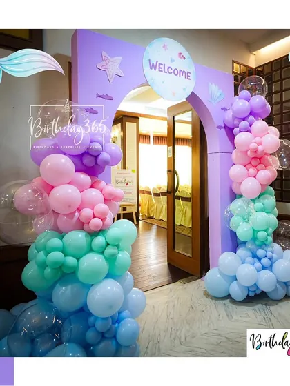 A welcoming entrance to our mermaid-themed party. Guests walked through a purple archway adorned with balloon "bubbles" in shades of pink, teal, and blue.