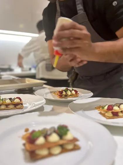 My team and I plating a mille-feuille dessert, carefully adding toppings to each individual portion.