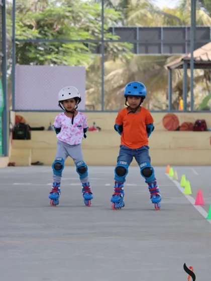 Two young beginners standing tall and finding their balance. This is the very first step in our roller skating lessons, and we make it a fun, no-pressure experience.