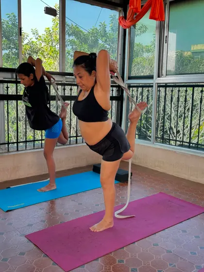 Using a yoga strap in Natarajasana (Dancer's Pose) helps to deepen the stretch in the shoulders and quadriceps while maintaining balance. This is a great example of how props assist in achieving correct form.