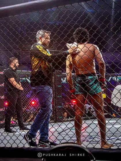 A coach giving instructions from outside the cage. This is the unseen part of the fight game.