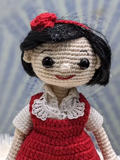 A detailed shot of the 'jija' doll's face and intricate collar work.