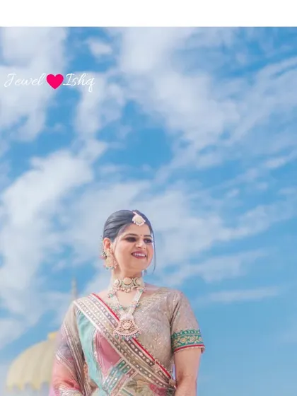 The bride against a beautiful blue sky, looking serene and happy. Her pastel jewellery adds a soft touch of color to the picturesque scene.