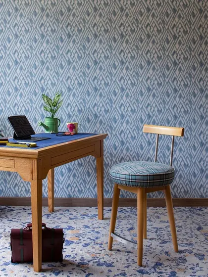 The smallest guest bedroom was reimagined as a multi-functional den. Wrapped in deep blues and playful patterns, it serves as a study area and hobbies corner, with light oak furniture keeping the space open and airy.