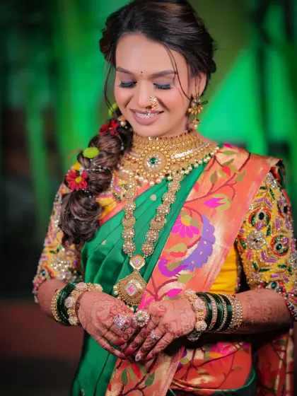 A beautiful candid moment of the bride looking down at her hands, showcasing the rich colors of her attire and the intricate henna art.