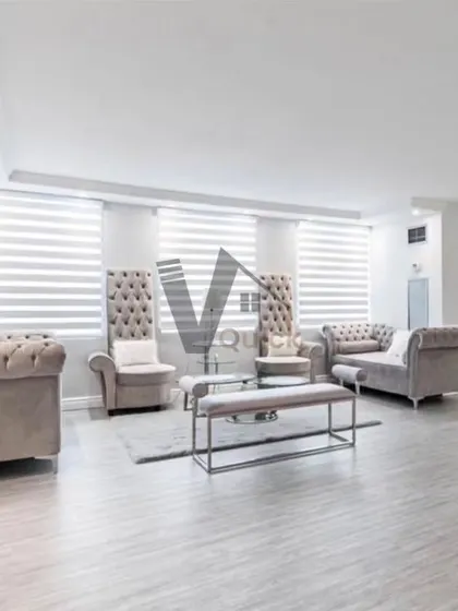 This wide shot displays an expansive and elegant living area. The use of high-back chairs and classic sofa shapes in a neutral color palette creates a grand yet inviting space, perfect for large families or entertaining guests.