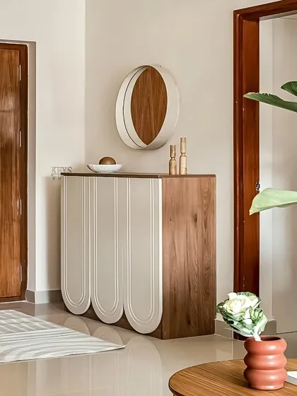This unique foyer console features a blend of wood and scalloped white panels. The design is both modern and playful, offering a stylish storage solution that makes a statement.
