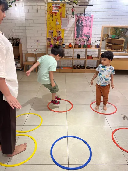 Jumping between hoops requires motor planning, balance, and concentration. We turn the floor into a game to make gross motor development feel less like work and more like an adventure.