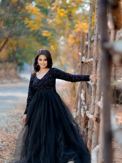 A beautiful shot capturing movement and style. The makeup remains flawless, highlighting her features against the backdrop of autumn leaves.