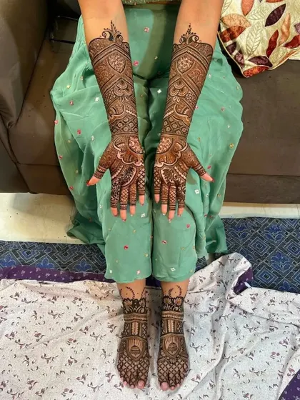 A complete bridal look showing the intricate designs on both hands and the matching simple patterns on the feet.