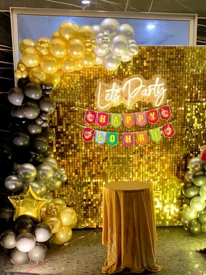 A festive Lohri celebration featuring a gold shimmer wall with a "Let's Party" neon sign and a colorful "Happy Lohri" banner.