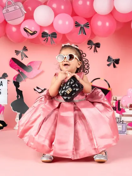This little fashionista is having fun with her props, showing off her playful side.