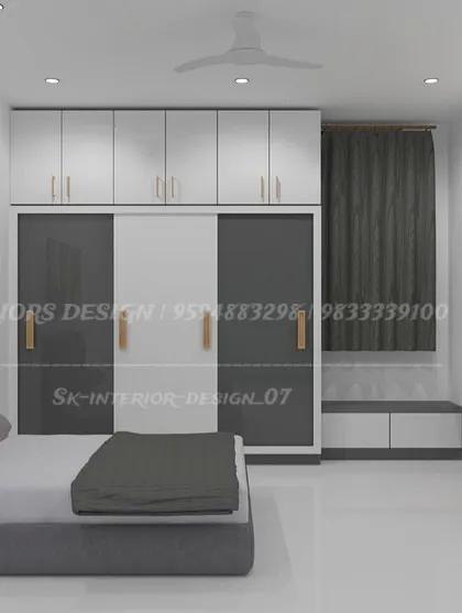 This bedroom combines a dual-tone sliding wardrobe with a compact TV unit. The design is clean and functional, with loft storage for seasonal items.