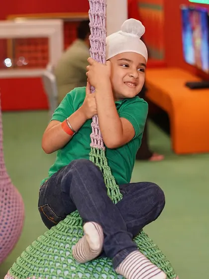 A young boy enjoys a relaxing moment on one of our woven pod swings.