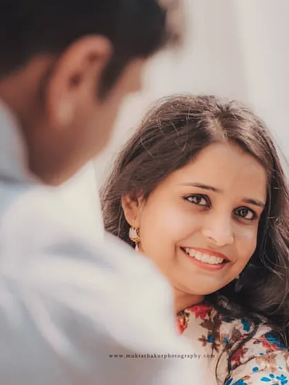 The beauty of a natural smile. This over-the-shoulder shot creates a personal and intimate feel, focusing entirely on her happy expression.