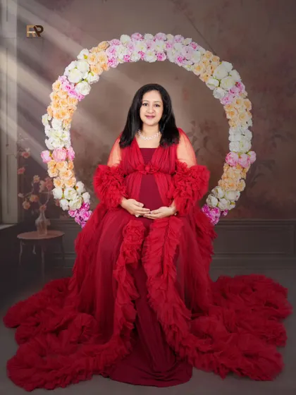 Framed by flowers. Our large floral hoop is one of our most requested props, creating a beautiful and romantic frame for your solo portraits. Here, it perfectly complements the client's stunning red gown.