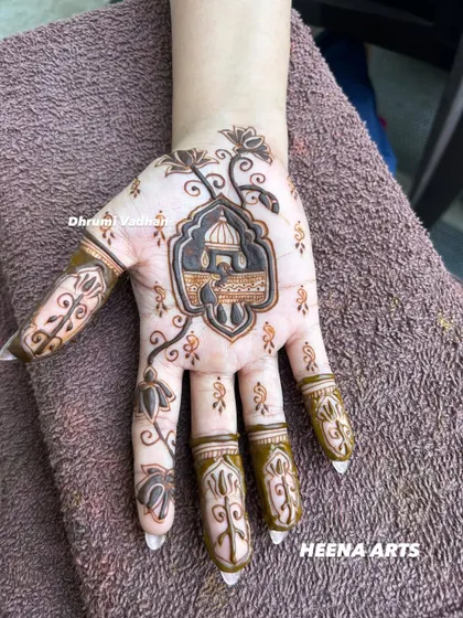 A unique and artistic design featuring a mosque silhouette on the palm, with delicate floral vines extending up the fingers.
