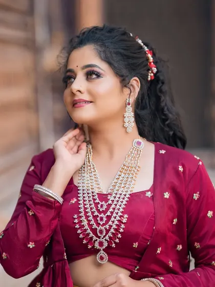 This layered CZ and ruby necklace provides a grand look, perfect for a reception or engagement ceremony. It pairs beautifully with rich colours like this maroon outfit.