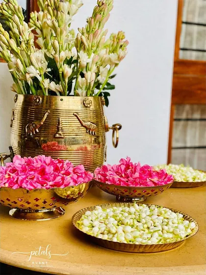 A close-up of the floral offerings for the wedding ritual, featuring tuberose, nerium, and jasmine in traditional brass bowls.
