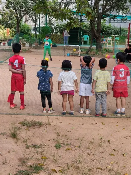 A group of children watches a teammate attempt to score, learning about teamwork and support.