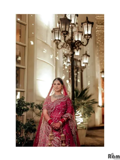 A classic bridal portrait taken at night, with the bride standing under elegant street lamps that create a beautiful bokeh effect.