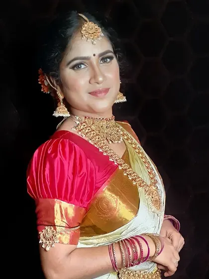 This profile view showcases the complete bridal styling, from the intricate hairstyle and maang tikka to the layered necklaces. Every element is carefully coordinated to create a cohesive and beautiful bridal look.