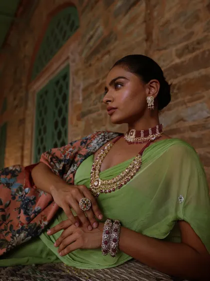 A serene yet opulent look from a heritage jewellery campaign. I styled a lime green saree with a floral cape and a stunning ruby choker and necklace set, creating a beautiful contrast against the rustic stone architecture.