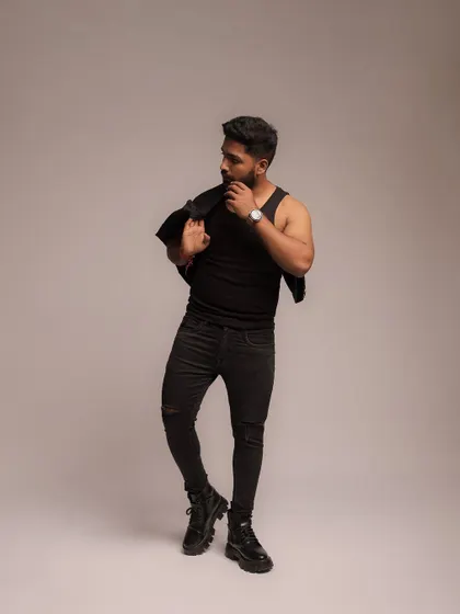A classic fashion pose, with the jacket slung over the shoulder, conveying a cool and relaxed attitude.