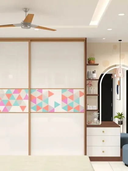 A playful and modern sliding wardrobe design for a kid's room. The white doors are accented with a band of colorful geometric triangles, adding a fun pop of color.