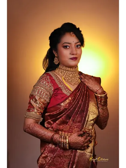 A classic studio-style bridal portrait. The warm backlighting creates a beautiful halo effect, highlighting her traditional attire.