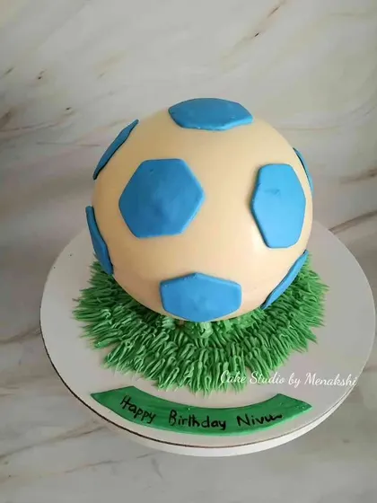 An exciting and interactive edible football piñata cake. The shell is made of chocolate, and you can smash it to reveal treats inside, making it a fun surprise for a birthday party.